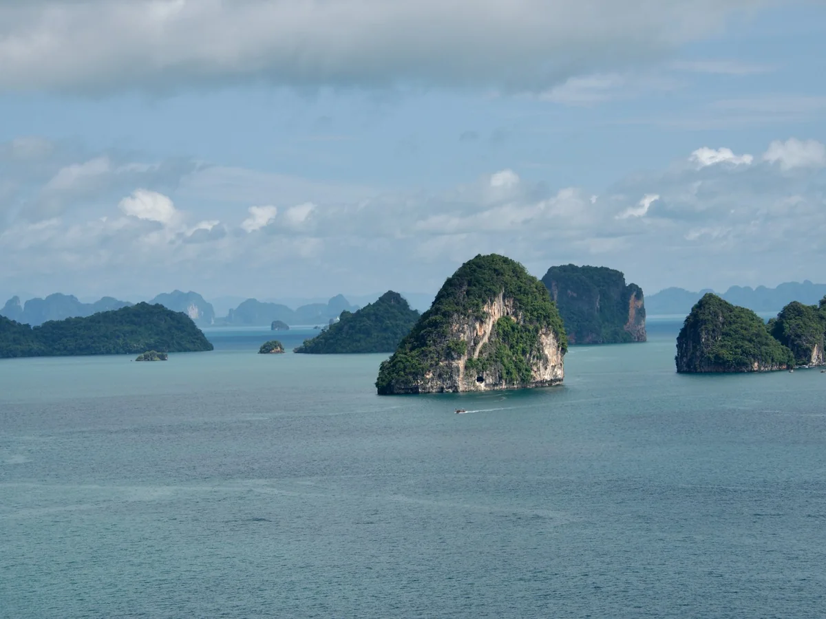 A wider view of Phang Nga Bay's scattered limestone karst islands from above the water